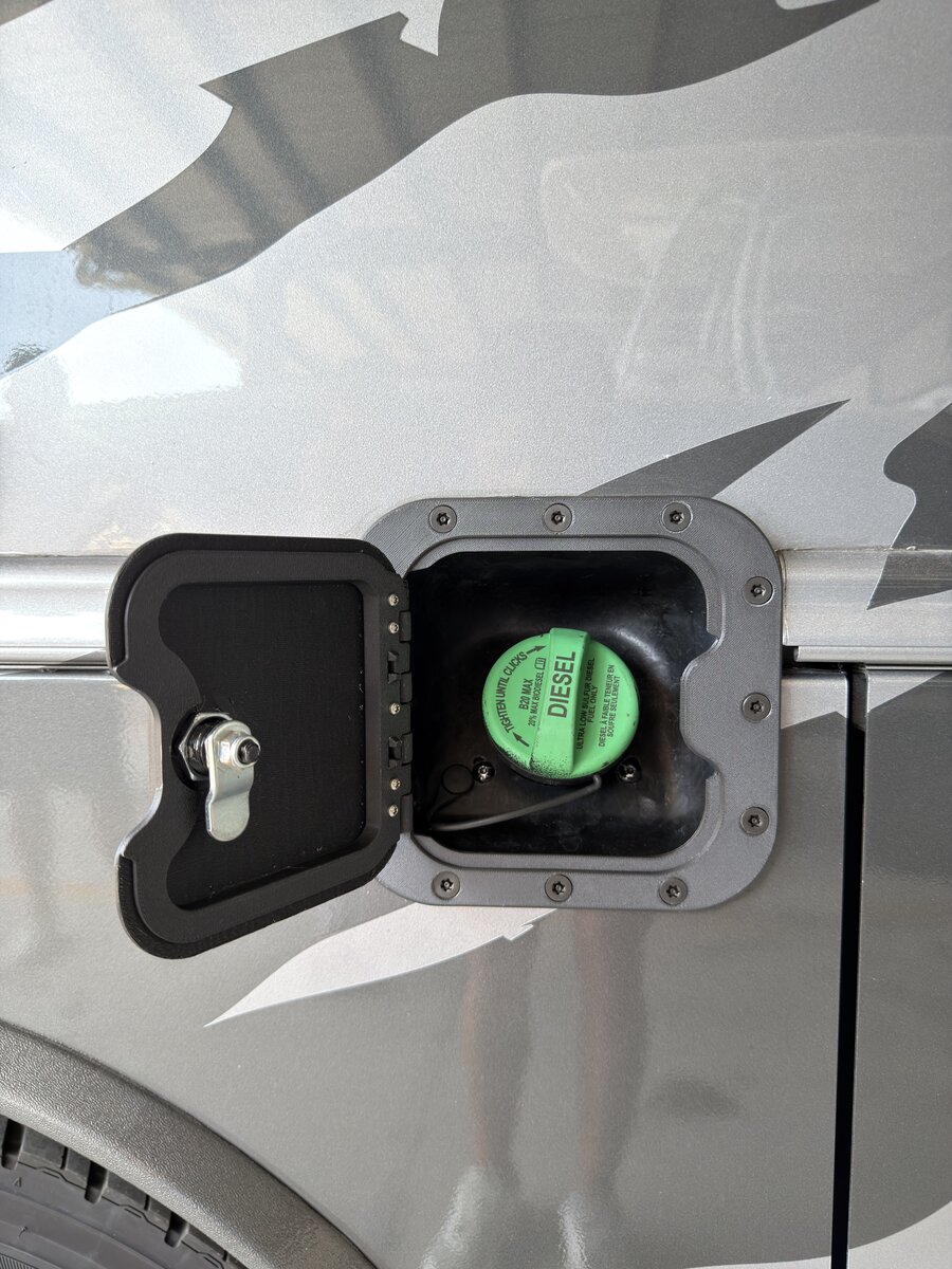 RV Fuel Vault fuel door open — green diesel cap visible with tamper-resistant bezel installed